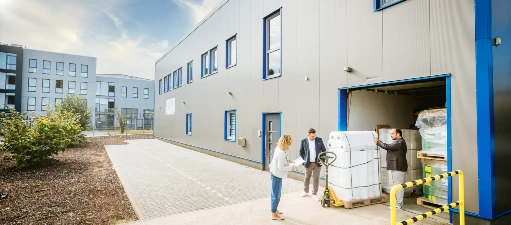 Ein Teil des Teams von Vogel Verpackungen steht vor der Lagerhalle und Prüft die neuste Lieferung von Stretchfolien